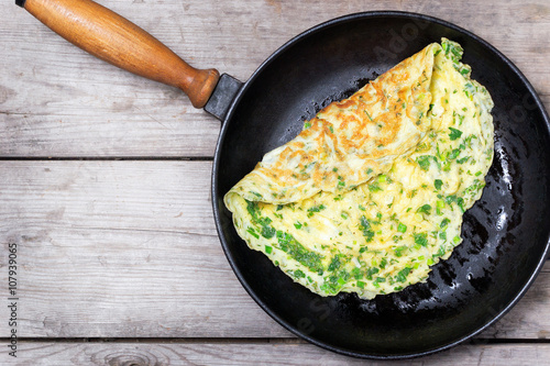 French omelet with herbs, cooked in cast iron skillet