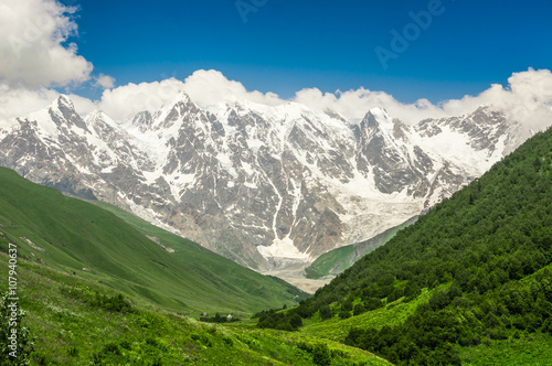 Grassy valley and snow-capped mountains in Georgia