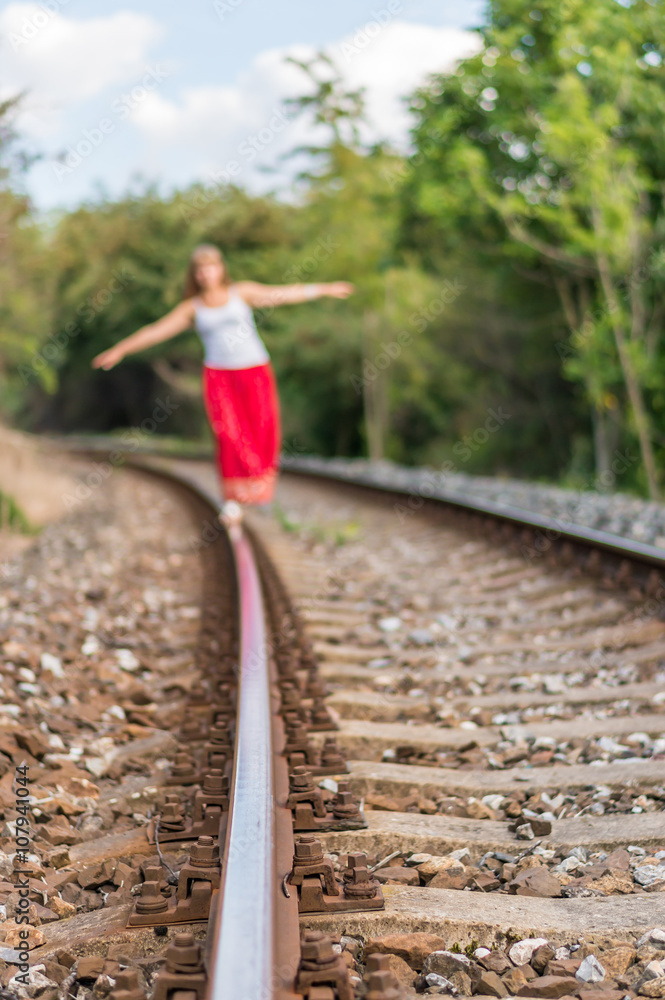 Young lady walking on railway tracks