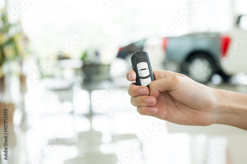 Human hands giving thumbs up with car key in car shoowroom © twinsterphoto