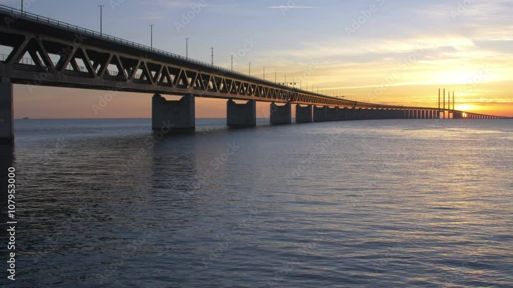 Oresundsbron at sunset. The bridge between Sweden and Denmark. Cars drive over the bridge Oresundsbron at sunset. The bridge between Sweden and Denmark. Cars drive over the bridge