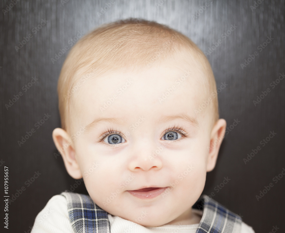 Portrait of a blue eyes baby leaning on the bed
