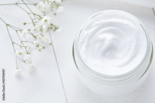 Hygienic cream bodycare product wellness and relaxation makeup mask in glass jar with towel on white background