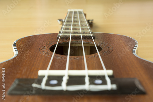 Close up of wooden ukulele on wooden background