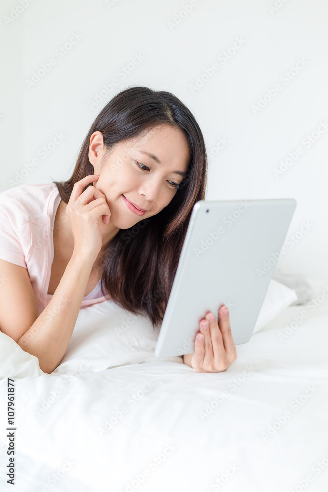 Woman use of tablet pc and lying on bed Woman use of tablet pc and lying on bed