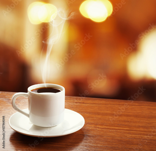 Cup of coffee on table on blured cafe background
