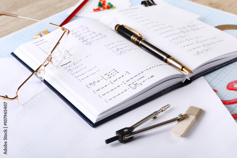 School supplies and textbook on mathematics close up School supplies and textbook on mathematics close up