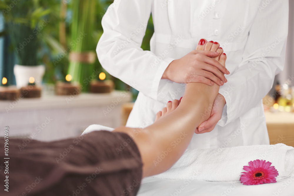 Beautiful young woman relaxing with leg massage at beauty spa Beautiful young woman relaxing with leg massage at beauty spa