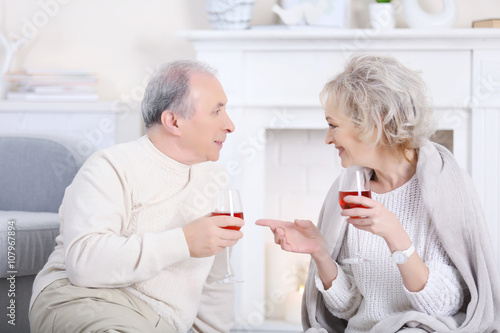 Happy mature couple drinking wine together at home