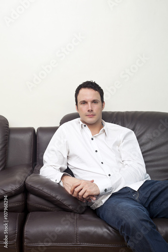 mid age man sitting in a sofa © Dan Kosmayer