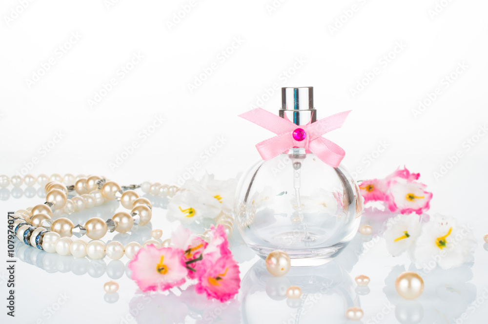 Perfume for women, pearl white beads, jewelry, pink flowers. Bottle of perfumes for women. Romantic concept on white background. Perfume for women, pearl white beads, jewelry, pink flowers. Bottle of perfumes for women. Romantic concept on white background.
