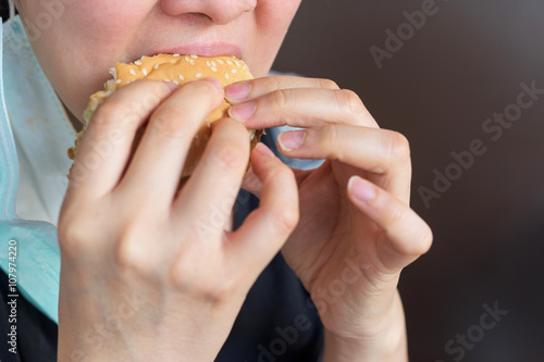 Asian girl eating hamburger
