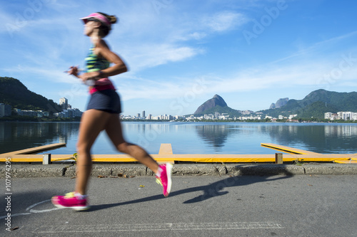 A jogger running past in motion blur a calm morning view of Lagao Rodrigo de Freitas lagoon, a popular recreation destination in Rio de Janeiro, Brazil