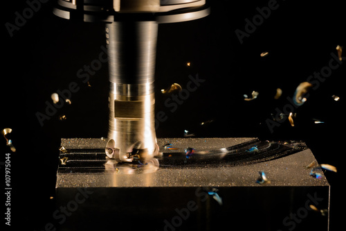 Milling cutter work with splinters flying off on a dark backgrou photo