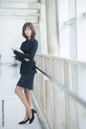 Attractive asian business woman working on tablet computer outsi