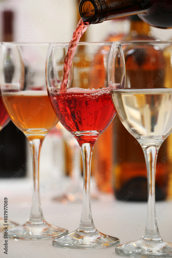 Red wine pouring into glasses, closeup Red wine pouring into glasses, closeup