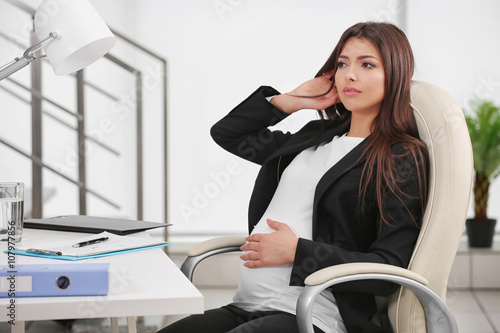 Pregnant woman sitting at h...
