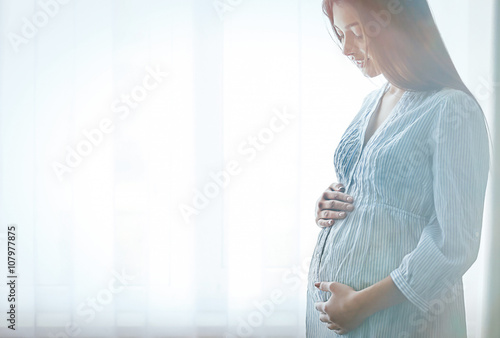 Pregnant woman standing nea...
