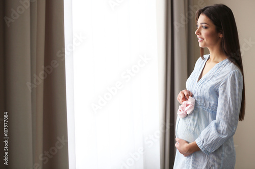 Pregnant woman standing nea...