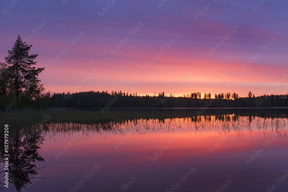 red and pink sunrise on the calm lake in the morning