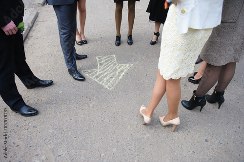 Chalk arrow on road, group of people around
