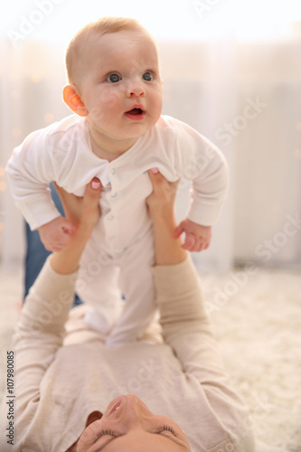 Woman playing with cute bab...