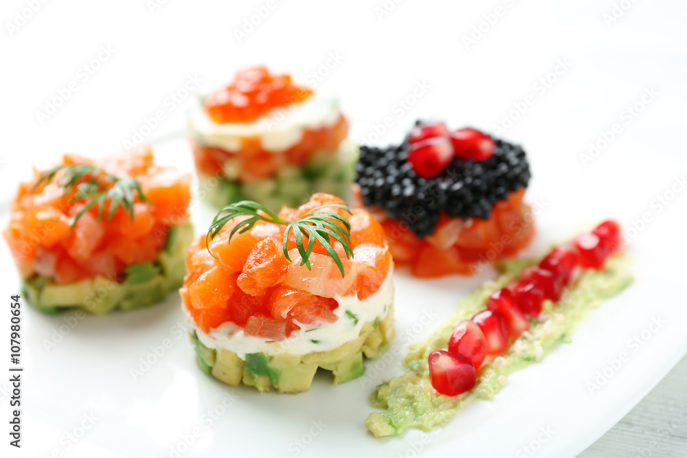 Delicious salmon tartare on white plate Delicious salmon tartare on white plate