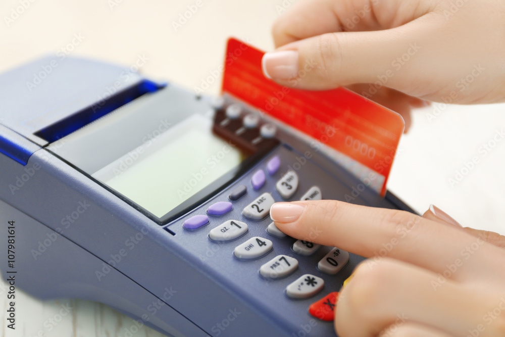 Female hand with credit card and bank terminal Female hand with credit card and bank terminal