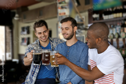 Group of happy friends drinking beer in pub © Africa Studio