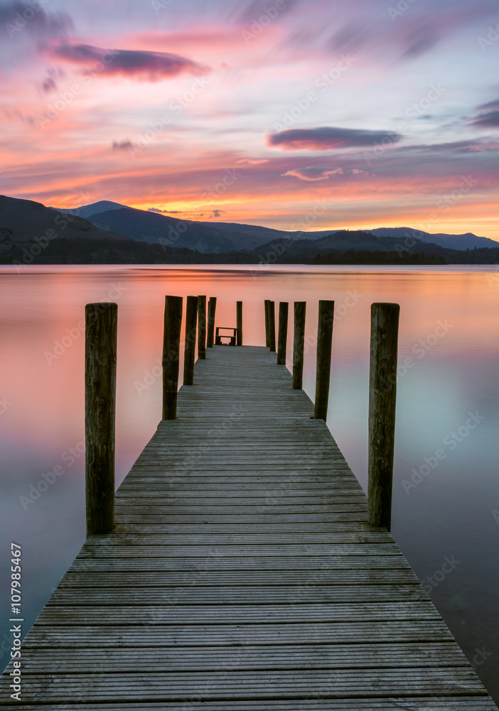 Fototapeta premium Żywy różowy i pomarańczowy zachód słońca w Ashness Jetty w Lake District, Wielka Brytania.