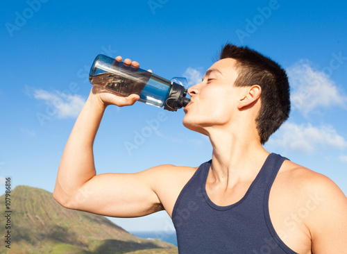 Young fit male drinking water. 