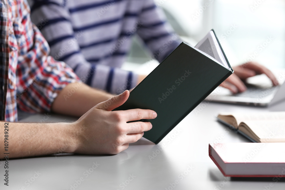 Student reading textbook at the table