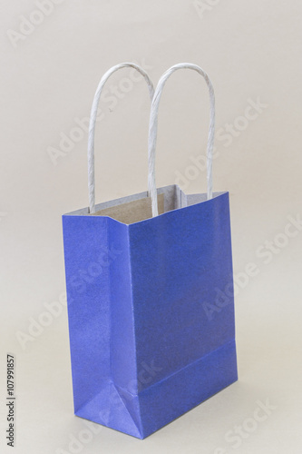 Paper blue shopping bag isolated on brown background
