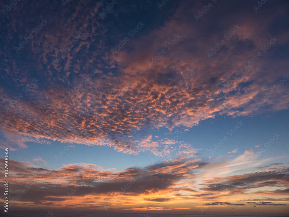 Sunset over the Atlantic Ocean composing a dramatic orange cloud