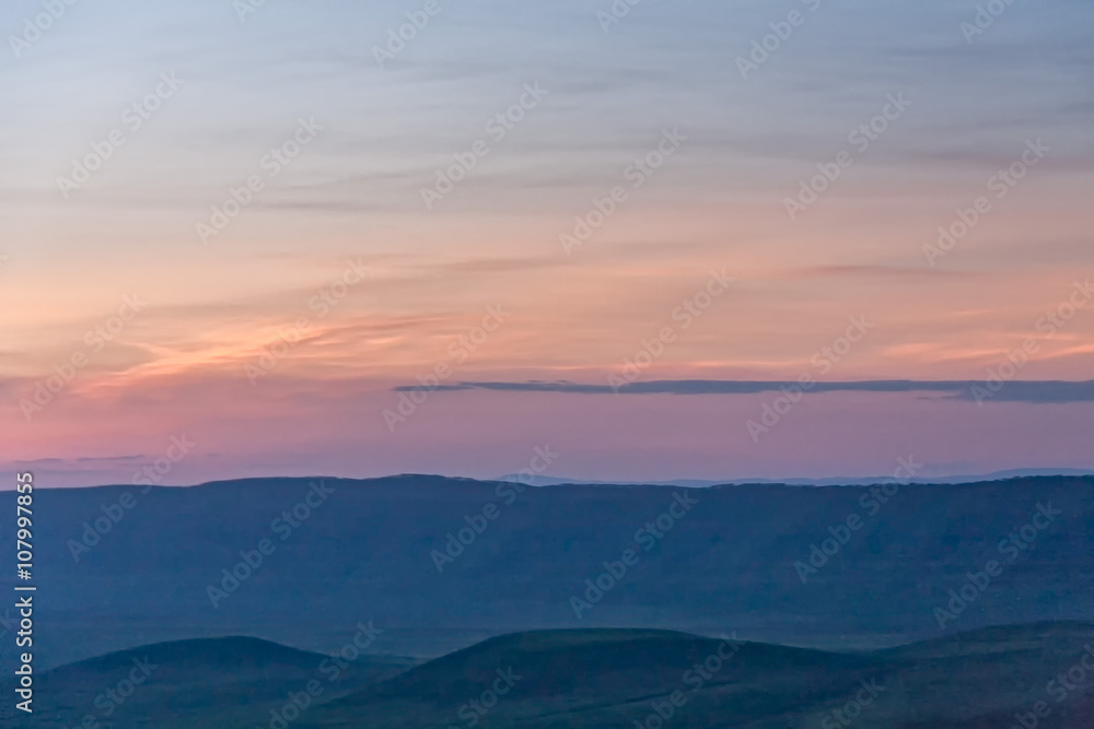 Panoramic view of huge Ngorongoro caldera (extinct volcano crater) against evening glow background at dusk. Great Rift Valley, Tanzania, East Africa.

