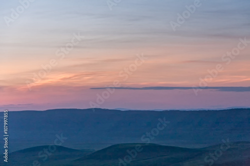 Panoramic view of huge Ngorongoro caldera (extinct volcano crater) against evening glow background at dusk. Great Rift Valley, Tanzania, East Africa. 