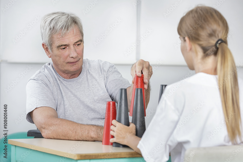 Fototapeta premium Senior with playing blocks and cones