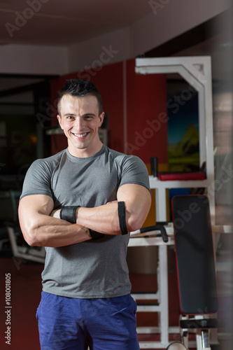 Portrait of muscular man with arms crossed in crossfit gym