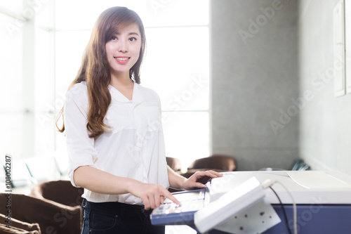 asian beautiful girl press button of copier