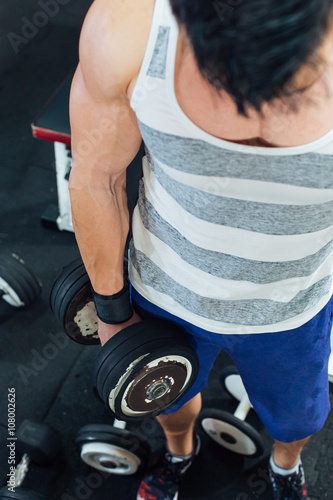 Top view of sporty man lifting weight at gym