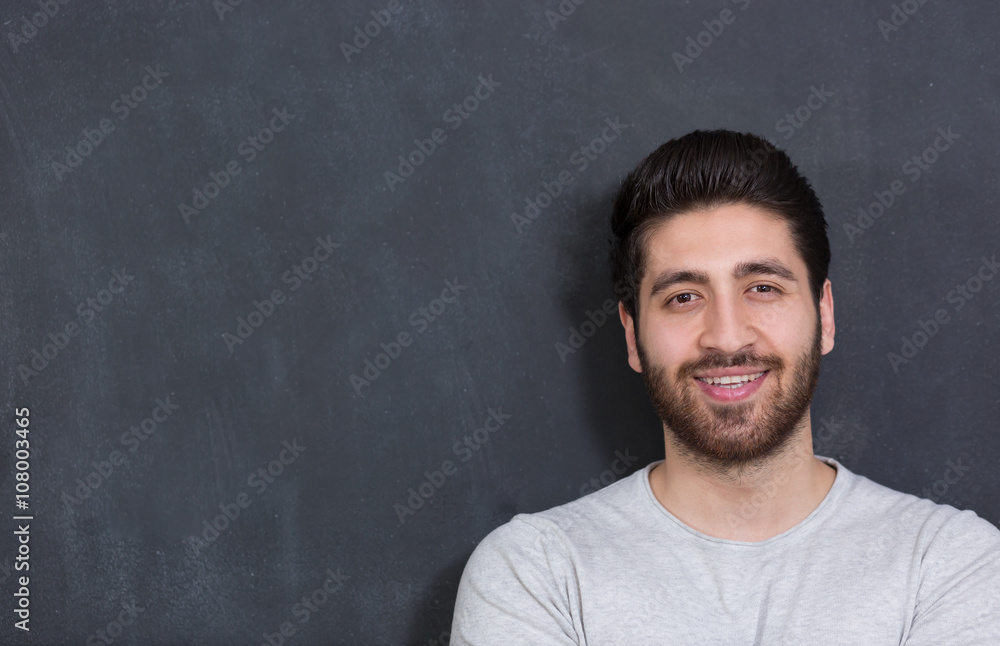 Handsome Young Man Smiling at the Camera Against chalkboard Wall Handsome Young Man Smiling at the Camera Against chalkboard Wall
