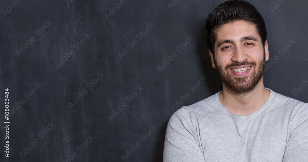 Handsome Young Man Smiling at the Camera Against chalkboard Wall