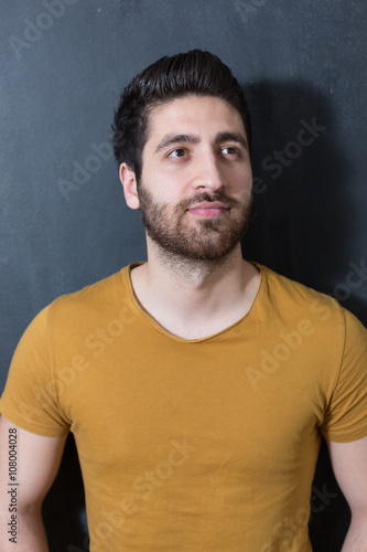 Portrait of a fashionable young man on dark background, chalkboa
