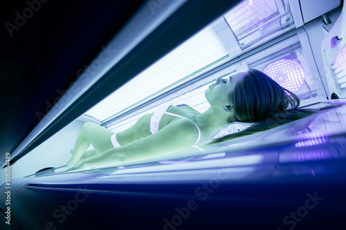 Beautiful woman tanning in solarium