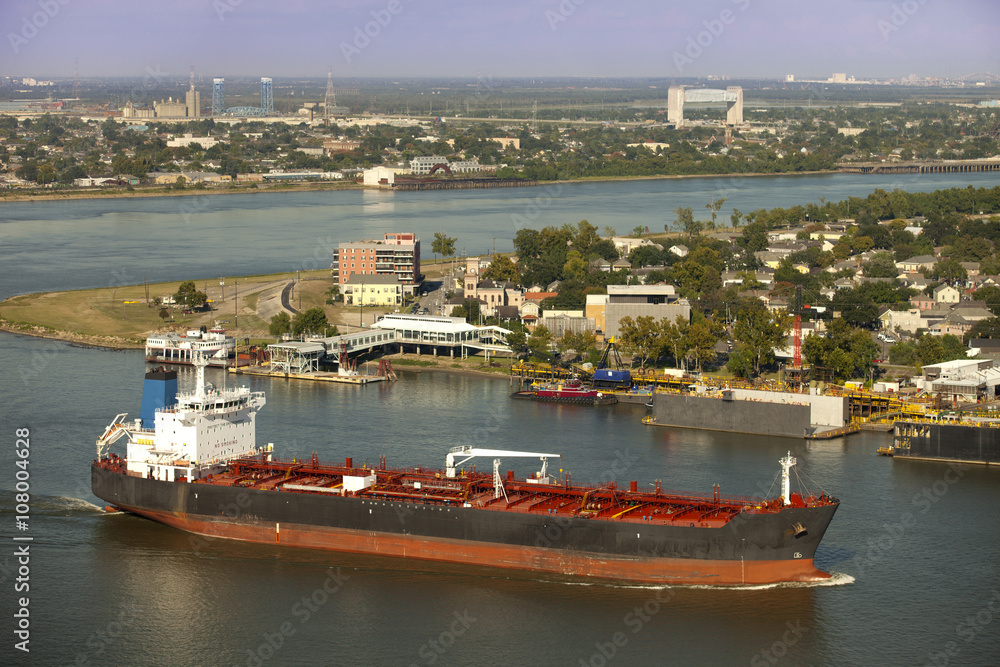 Obraz premium Industral tanker going around Algiers Point on the Mississippi River in New Orleans, Louisiana with Bywater, Holy Cross and Lower Ninth Ward in the background.
