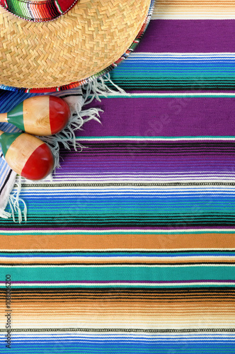 Mexico cinco de mayo background with mexican sombrero striped traditional serape rug blanket and maracas fiesta carnival photo