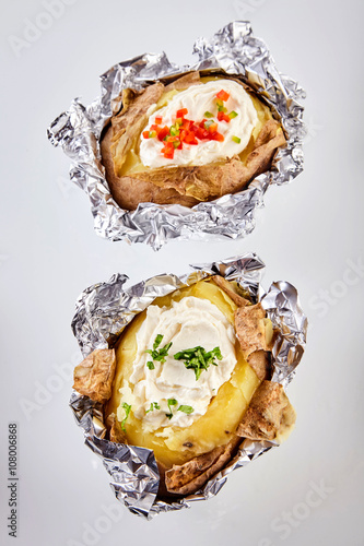 Konstfotografi Two barbecued baked potatoes in tin foil