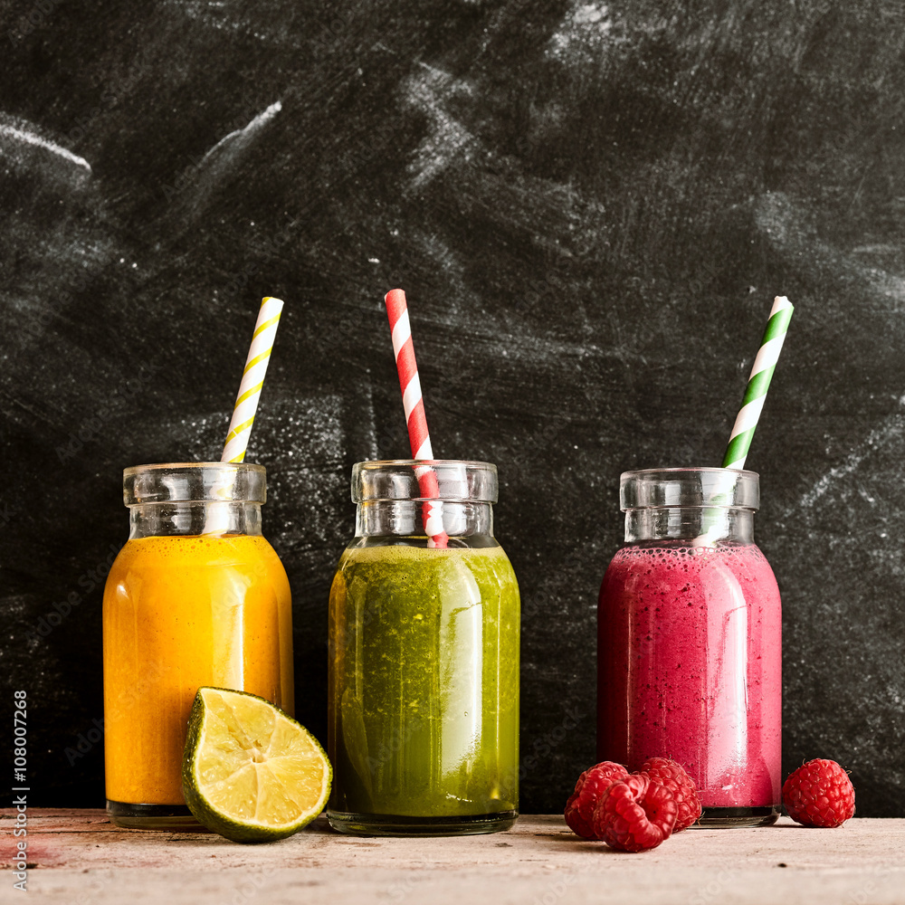 Three jars of tropical fruit beverages with straws Three jars of tropical fruit beverages with straws