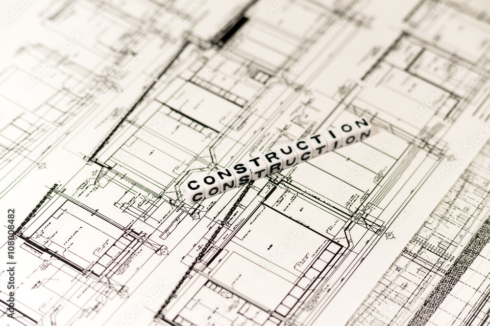 Construction drawing and CONSTRUCTION on white cube Construction drawing and CONSTRUCTION on white cube