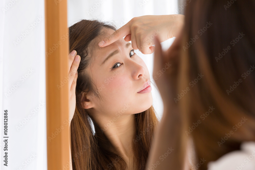 Fototapeta premium 鏡・生え際を気にする女性